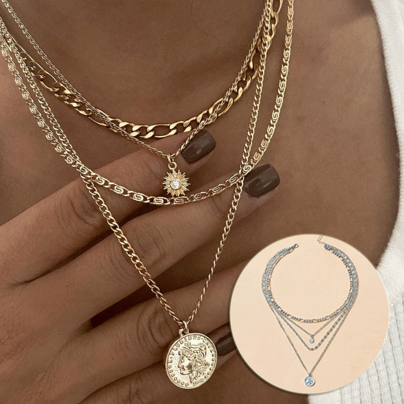 Layered gold necklace for women with coin pendants and water wave chain design.