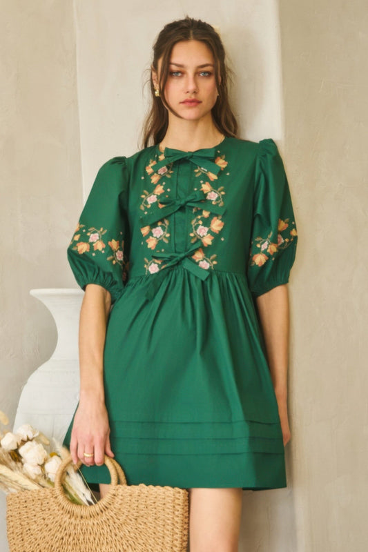Poplin front ribbon tie baby doll dress with embroidery detail.